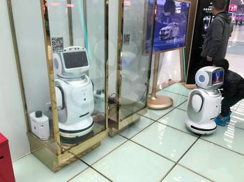 CHANGSHA, CHINA - MARCH 21, 2017: people play with promotion robots in hall of railway station in Changsha city. Changsha is the capital of Hunan province, city has about 7 mln residents