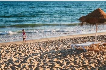 Travel to Algarve Portugal - girl plays on beach Praia Falesia near Albufeira city
