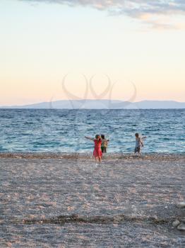 travel to Greece - children play on urban beach of Aegean Sea in Athens city in evening