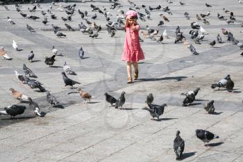 travel to Greece - girl chasing pigeons on urban square in Athens city