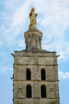 Travel to Provence, France - golden statue the Virgin Mary on top of bell tower of Cathedral of Our Lady of Doms in medieval Papal Palace in Avignon city