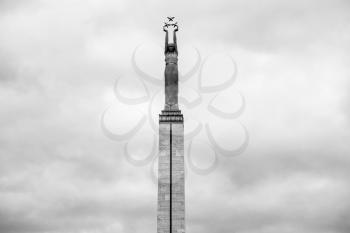 travel to Latvia - Freedom Monument with figure of Liberty and gray clouds in Riga city in autumn