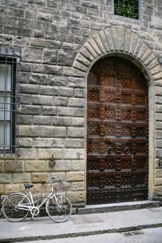 travel to Italy - bicycle near door of medieval house on street in Florence city in winter day