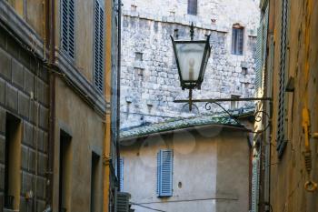 travel to Italy - lantern between medieval houses on street in Siena city in winter
