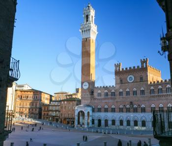 travel to Italy - view of Piazza del Campo (Campo square) with town hall and Mangia tower in Siena city in winter. The historic centre of Siena town has been declared by UNESCO a World Heritage Site