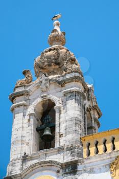 Travel to Algarve Portugal - stork on bell tower of Igreja do Carmo (Igreja da Ordem Terceira de Nossa Senhora do Monte do Carmo, Carmo Church) church in Faro city