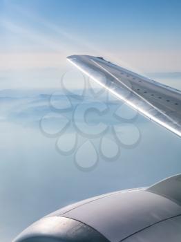 View from the airplane - wing of aircraft and view of mountains and Aegean Sea under light clouds in Greece in autumn
