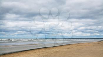 travel to Latvia - low gray clouds over beach of Gulf of Riga of Baltic Sea in seaside resort Jurmala town in autumn