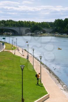 AVIGNON, FRANCE - JULY 7, 2008: tourists on waterfront of Rhone River in center of Avignon city. Avignon city historic centre became UNESCO World Heritage Site in 1995