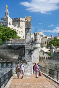 AVIGNON, FRANCE - JULY 7, 2008: tourists walk to historical palace Palais des Papes (Papal palace) in Avignon town. Avignon city historic centre became UNESCO World Heritage Site in 1995