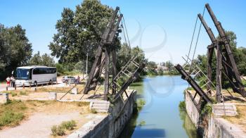 ARLES, FRANCE - JULY 7, 2008: visitors near Pont Van Gogh, replica of the Langlois Bridge, drawbridge which was the subject of several paintings by Vincent van Gogh in 1888, on Canal d'Arles a Fos