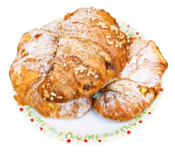 three fresh italian croissants filled by vanilla and chocolate on plate isolated on white background