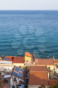 travel to Sicily, Italy - above view of residential houses in Giardini Naxos town and Ionian Sea at summer sunset