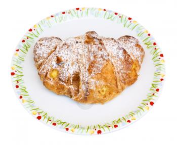 fresh italian croissant filled by vanilla cream on plate isolated on white background