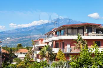 travel to Sicily, Italy - residential buildings on street via ischia in Giardini Naxos town and view of Etna Mount in summer