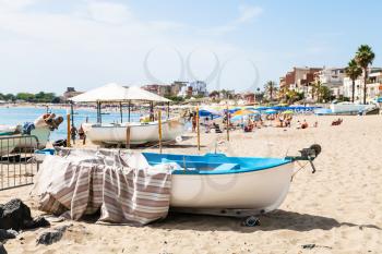 travel to Sicily, Italy - boats on urban beach in Giardini Naxos town in summer