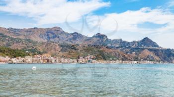 travel to Sicily, Italy - panoramic view of Giardini Naxos town and Taormina city on cape in summer