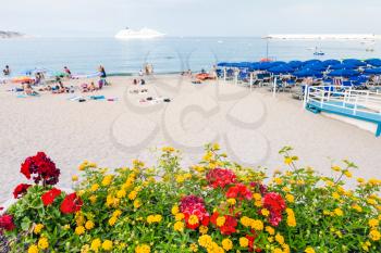 travel to Sicily, Italy - flowerbed on waterfront of urban beach in Giardini Naxos town in summer evening