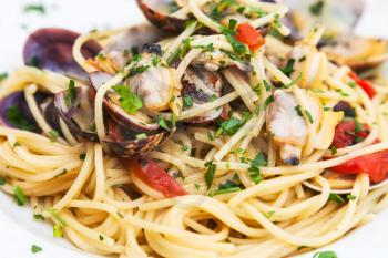 typical italian food - spagetti with vongole clams on plate close up in sicilian restaurant