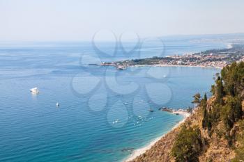 travel to Sicily, Italy - view of Giardini Naxos town on coast of Ionic sea from Belvedere viewpoint at Piazza 9 Aprile in Taormina city