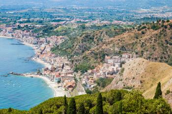 travel to Sicily, Italy - above view of Giardini Naxos town of coast of Ionian Sea from Taormina city in summer day