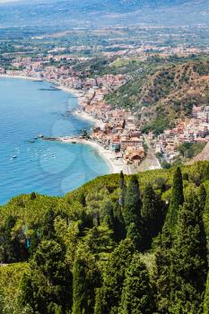 travel to Sicily, Italy - above view of Giardini Naxos town of shore of Ionian Sea from Taormina city in summer day