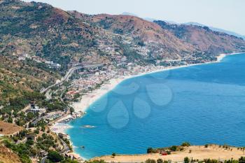 travel to Sicily, Italy - above view of Letojanni resort town of shore of Ionian Sea from Taormina city in summer day