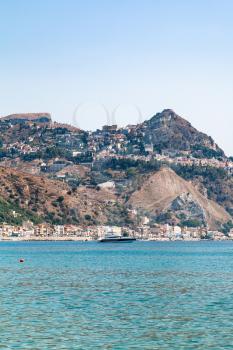travel to Sicily, Italy - view of Taormina city on cape and in Giardini Naxos town on coast of Ionian sea in summer