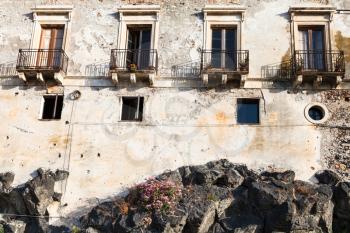 travel to Sicily, Italy - old house on volcanic rock base in Giardini Naxos town in summer