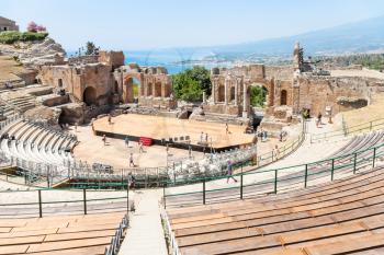 TAORMINA, ITALY - JUNE 29, 2017: people in Teatro antico di Taormina, ancient Greek Theater (Teatro Greco) in Taormina city in summer day. The amphitheater was built in the third century BC