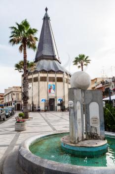 GIARDINI NAXOS, ITALY - JUNE 28, 2017: piazza San Giovanni with church of Santa Maria Immacolata and fountain in Giardini-Naxos. Giardini Naxos is seaside resort on Ionian Sea coast since the 1970s