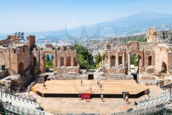 TAORMINA, ITALY - JUNE 29, 2017: people in Teatro antico di Taormina, ancient Greek Theater (Teatro Greco) and view of Etna mount in summer day. The amphitheater was built in the third century BC