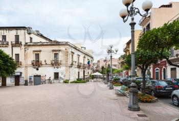 GIARDINI NAXOS, ITALY - JUNE 28, 2017: view of Piazza Municipio with Town Hall and monument in Giardini-Naxos in summer evening. Giardini Naxos is seaside resort on Ionian Sea coast since the 1970s