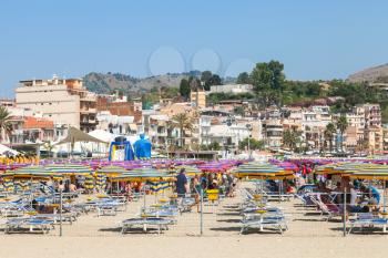 GIARDINI NAXOS, ITALY - JUNE 30, 2017: people on urban beach in Giardini-Naxos city in summer. Giardini Naxos is seaside resort on Ionian Sea coast since the 1970s