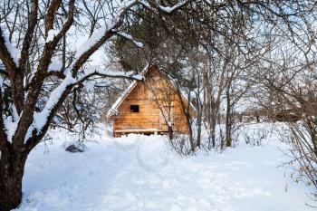 new little timber cottage in snow-covered garden in winter in Smolensk region of Russia