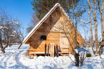 view of little timber cottage and wide skis in sunny winter day in Smolensk region of Russia