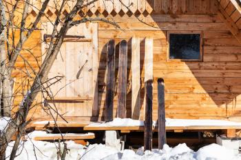 wide hunter skis in front of wooden cottage in sunny winter day in russian village in Smolensk region of Russia