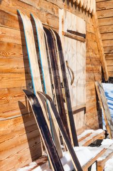 wide hunting skis near wall of wooden cottage in winter in russian in village in Smolensk region of Russia