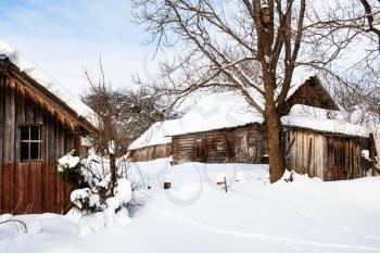 snow-covered yard in abandoned old typical russian village in winter day in Smolensk region of Russia
