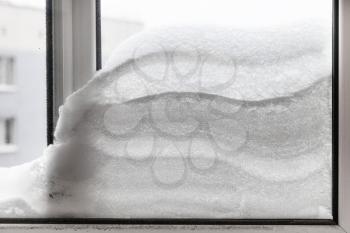 snowdrift between two window glasses in winter day in Moscow city