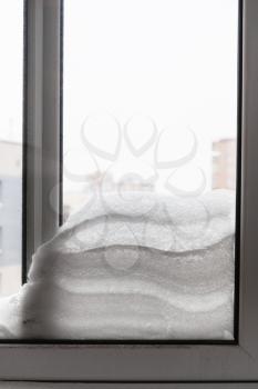 snow between two window glasses in winter day in Moscow city