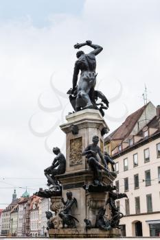 Travel to Germany - back side view of Herkulesbrunnen (Hercules fountain) on Maximilianstrasse street in Augsburg city in rainy spring day