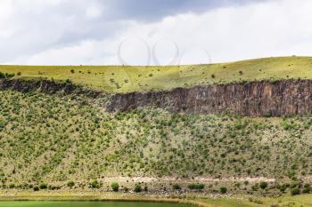 Travel to Turkey - green slope of old crater with Narligol Lake (Lake Nar) in Geothermal Field in Aksaray Province of Cappadocia in spring