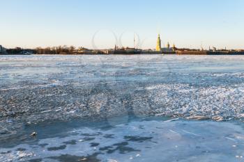 view of frozen Neva river and Peter and Paul Fortress in Saint Petersburg city in March evening