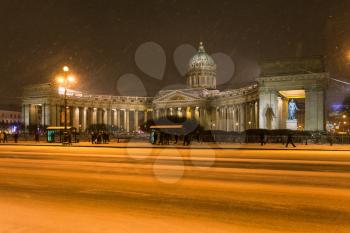 view of Kazan Cathedral on snowy Nevsky Prospect street in night snowfall in Saint Petersburg city in March