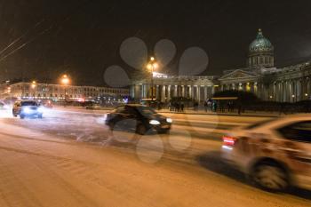 view of snowy Nevsky Prospect with Kazanskiy Cathedral in night snowfall in Saint Petersburg city in March