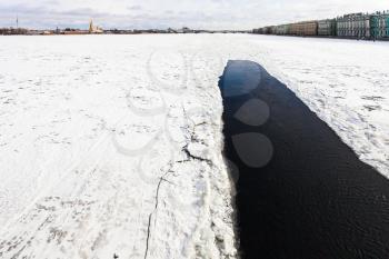 view of frozen Neva river with polynya near Dvortsovaya embankment in Saint Petersburg city in March