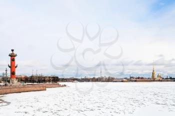 view of frozen Neva river and Spit of Vasilyevsky Island with Rostral Column and Peter and Paul Fortress in Saint Petersburg city in march