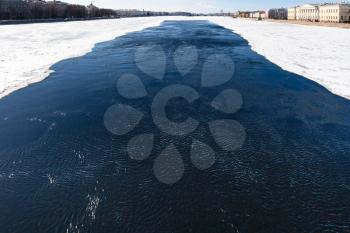 dark water in polynya in Neva river near The Palace Bridge in Saint Petersburg city in March