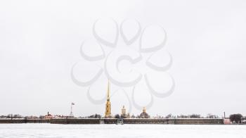 gray cloudy sky over frozen Neva river and Peter and Paul Fortress in Saint Petersburg city in March